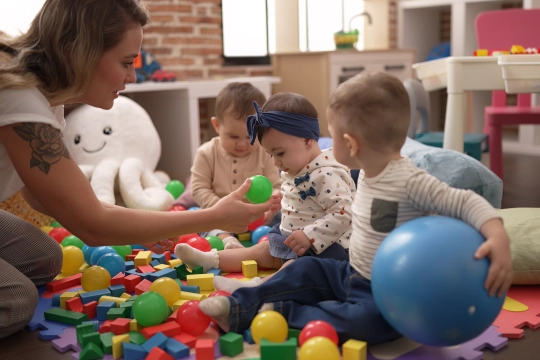 teacher-preschool-students-playing-with-balls-sitting-floor-kindergarten